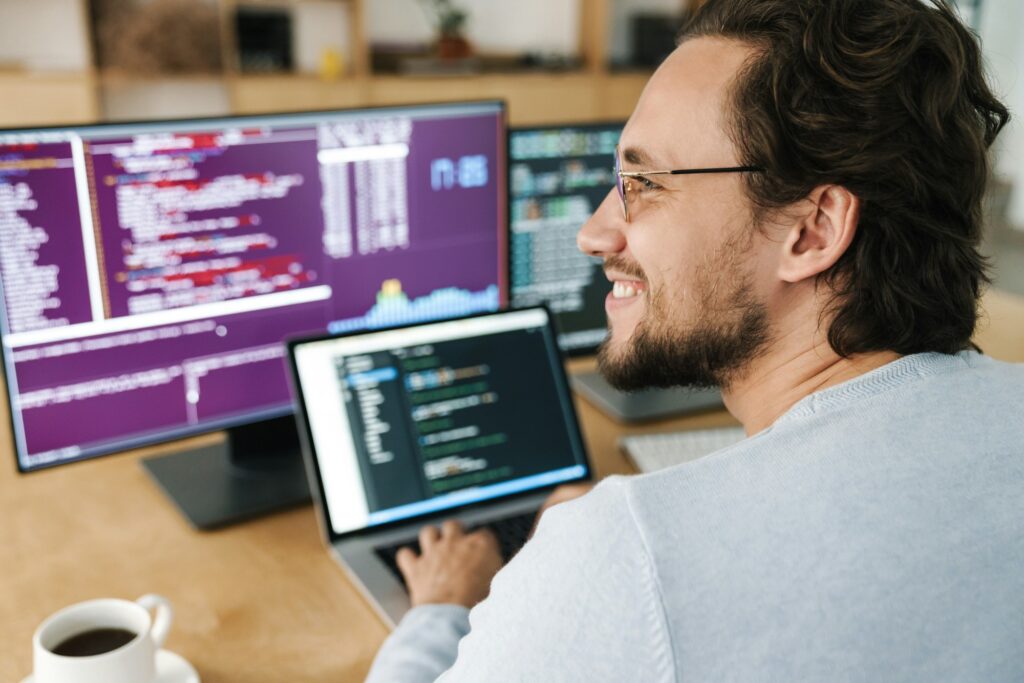 Image of programmer man wearing eyeglasses working with computers