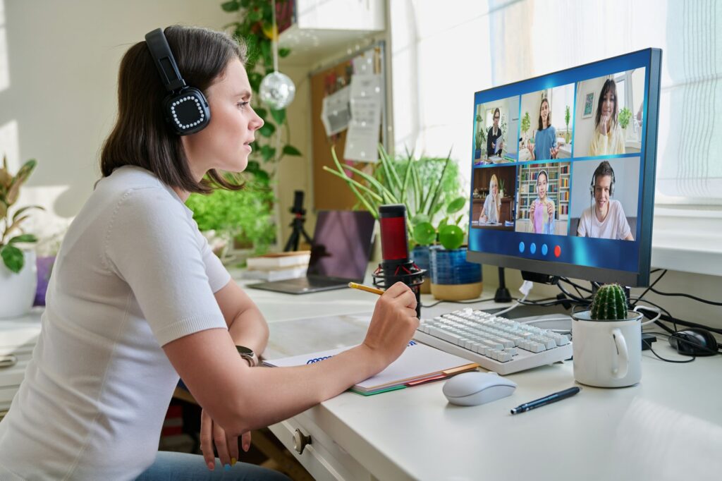 Teacher looking at pc screen, online lesson with group of teenage students